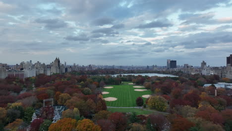 Vorwärtsflug-über-Central-Park.-Der-Große-Rasen-Mit-Baseballfeld-Und-Jacqueline-Kennedy-Onassis-Reservoir,-Umgeben-Von-Herbstfarbenen-Bäumen.-Manhattan,-New-York-City,-Vereinigte-Staaten