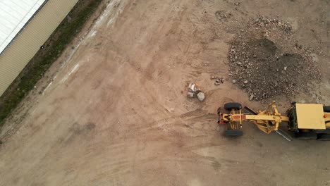 slow flyover of a construction grader in a dirt parking lot