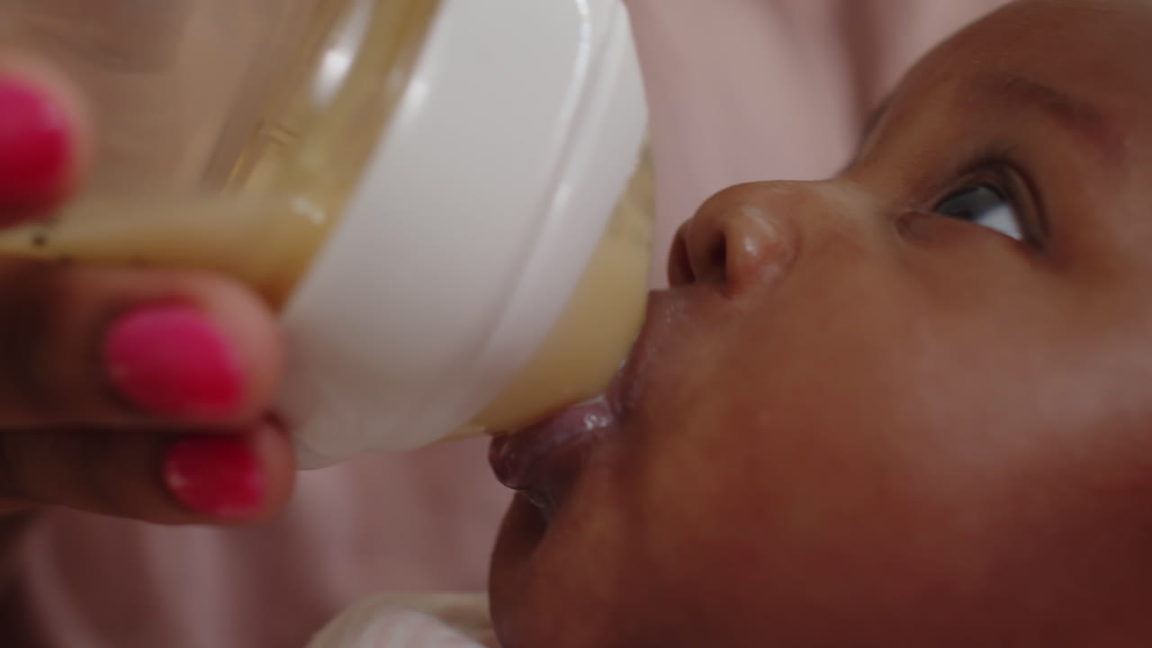 Neonato carino che succhia il latte artificiale dal biberon
