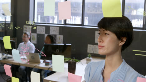 Female-executive-looking-at-sticky-notes-in-office-4k