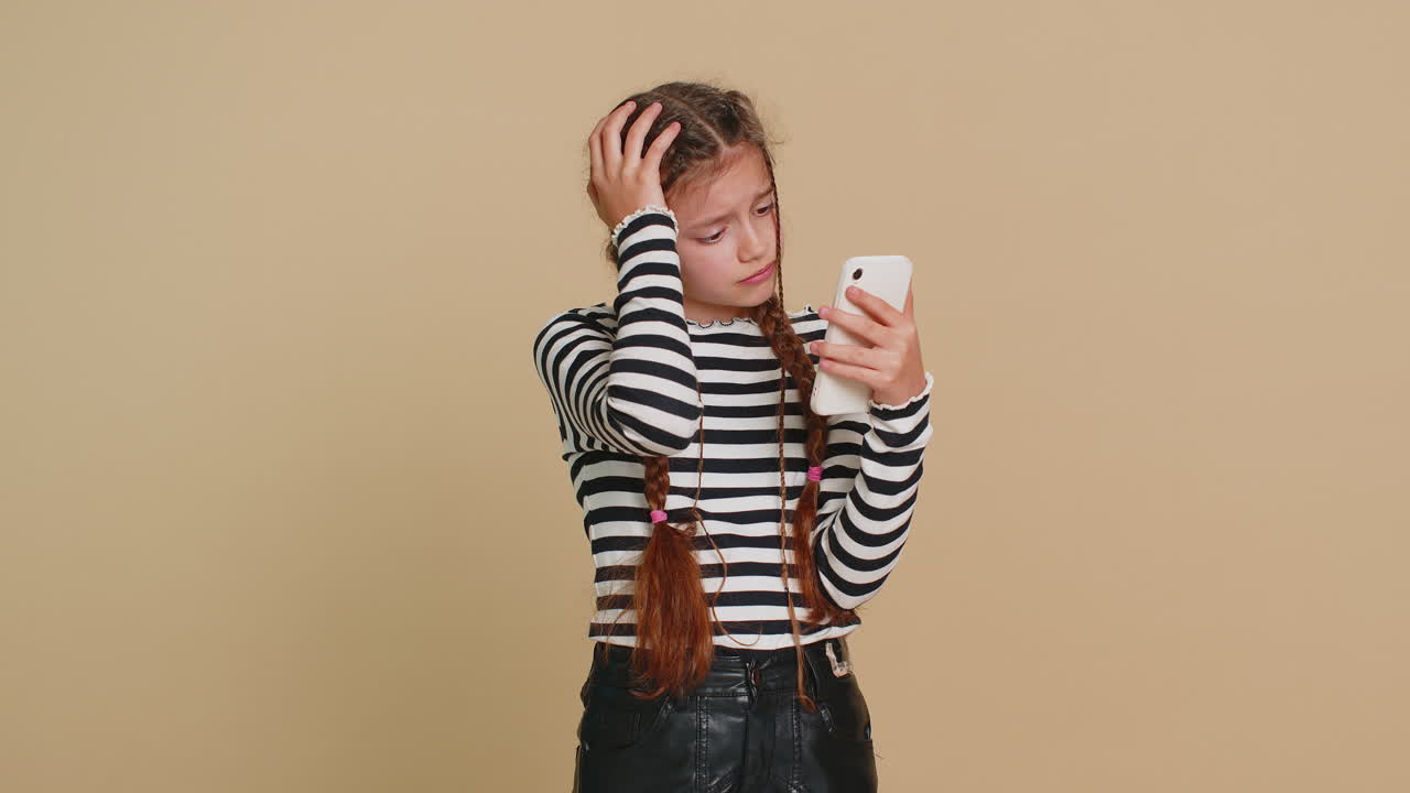 Upset sad child girl use smartphone play game loses loss fail unlucky news bad lottery result crisis