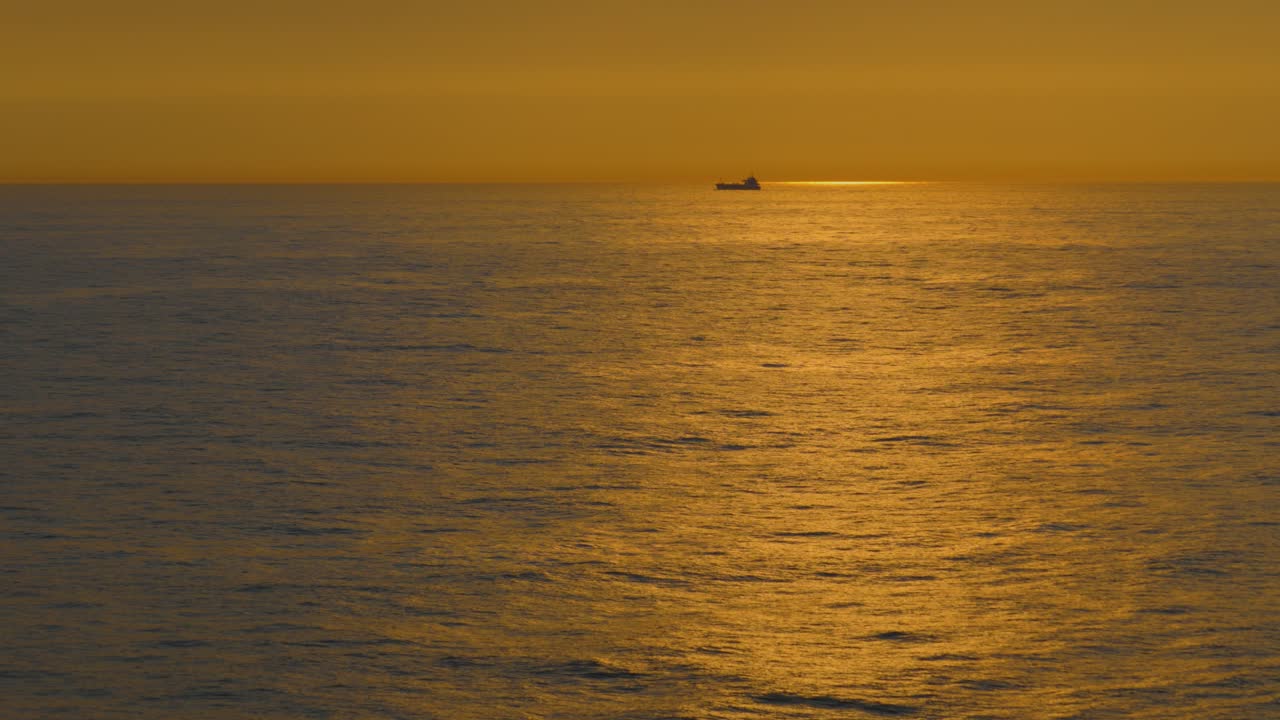 Sunset over the Ocean with a Cargo Ship