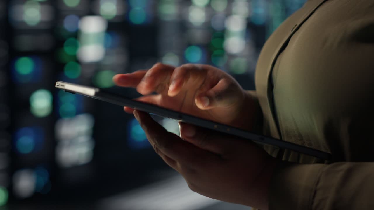 Close up of technician working in data center using tablet