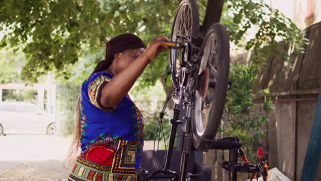 mujer ajustando bien la bicicleta en el patio