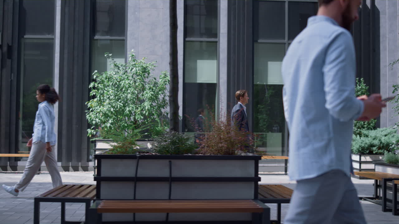 una donna d'affari sicura di sé che va al lavoro in un cortile di ufficio grigio moderno.