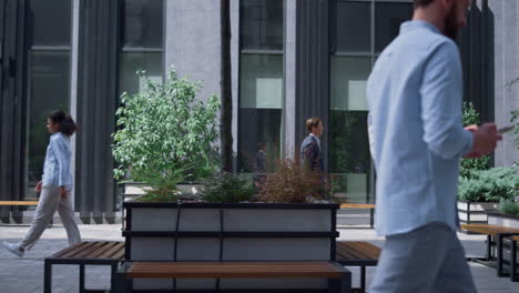 Confident-business-woman-walking-to-work-occupation-in-modern-gray-office-yard.