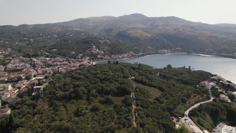 Drone-Sobrevuelo-Colina-Boscosa-Hacia-Kassiopi-Beach-Bay,-Isla-De-Corfú,-Grecia,-Día-Nublado