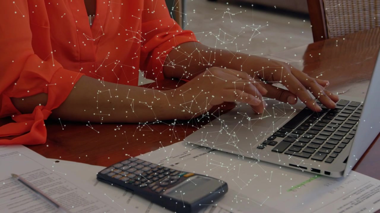 Femme posant les mains sur le clavier d'un ordinateur portable et tapant tout en utilisant une superposition de calculatrice pour analyser les finances.