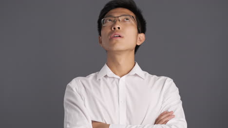 asian man rolling his eyes in front of the camera.