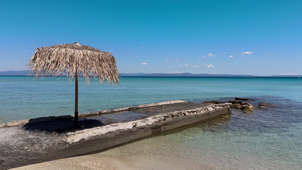 Stunning beach scene in Halkidiki, Greece, with elegant sunbeds facing the crystal-clear turquoise sea. A perfect summer escape in the heart of the Aegean.
