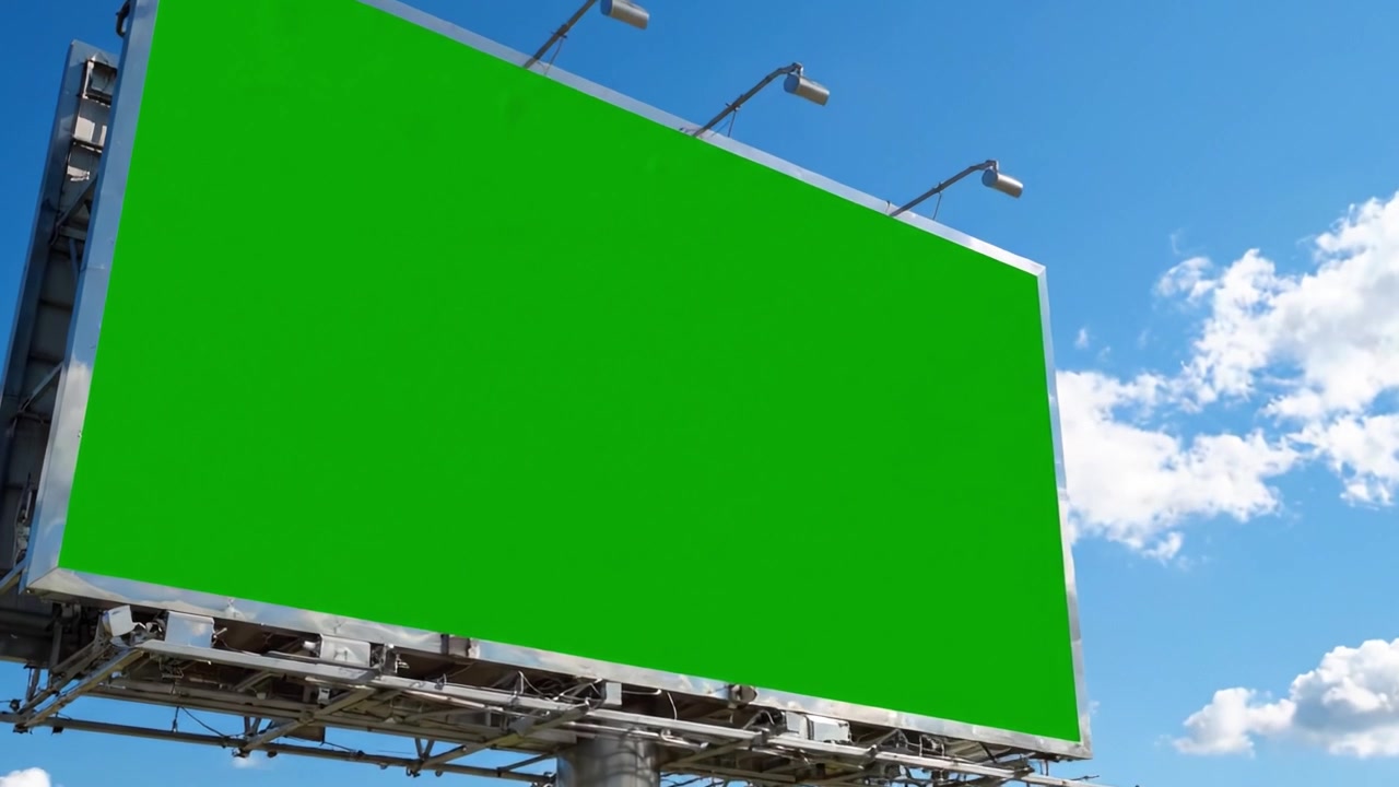 Grande cartellone pubblicitario verde contro un cielo azzurro limpido circondato da alberi rigogliosi, ideale per la pubblicità con ampio spazio per messaggi o branding