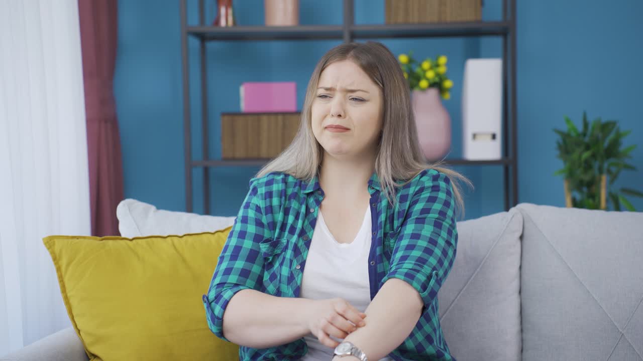 mujer joven con picazón en los brazos.