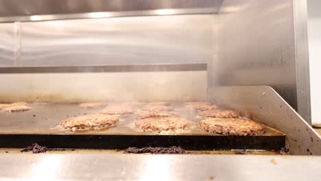 burger meat patties sizzling over a flat surface grill