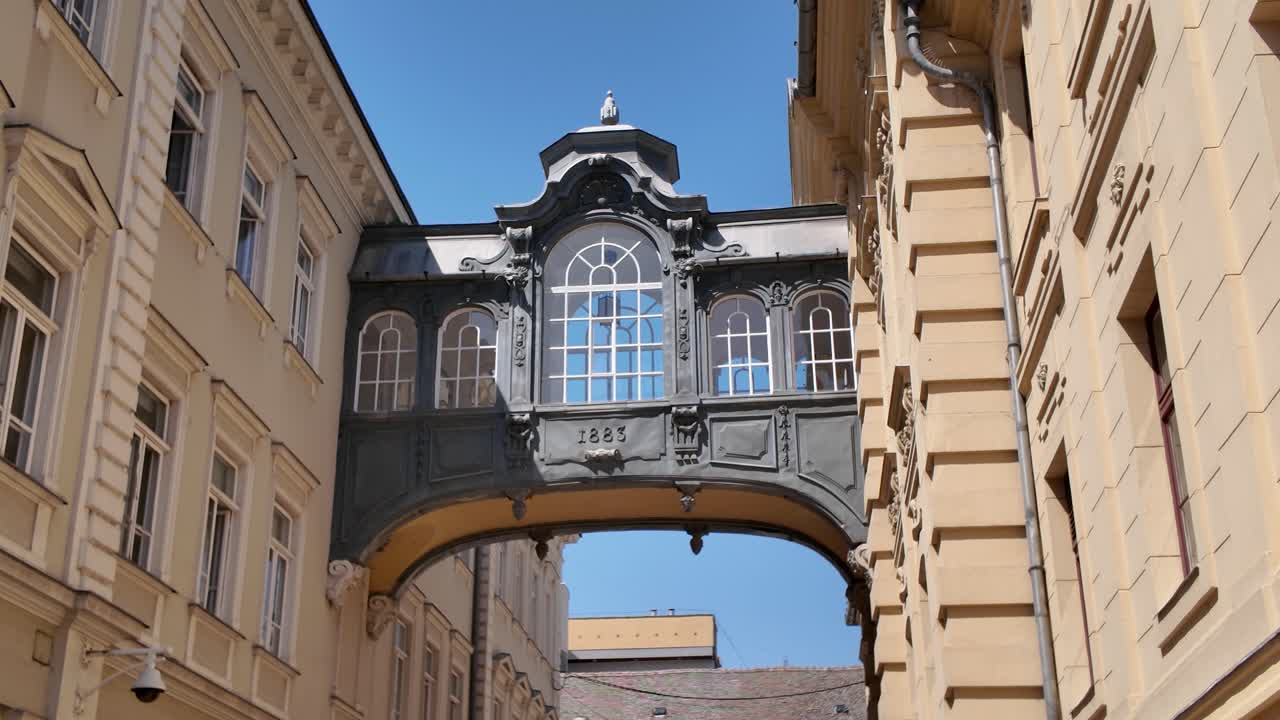 Exterior footage of the Bridge of Sighs in Szeged, Hungary, connecting City Hall to an adjacent building, showcasing historic architecture
