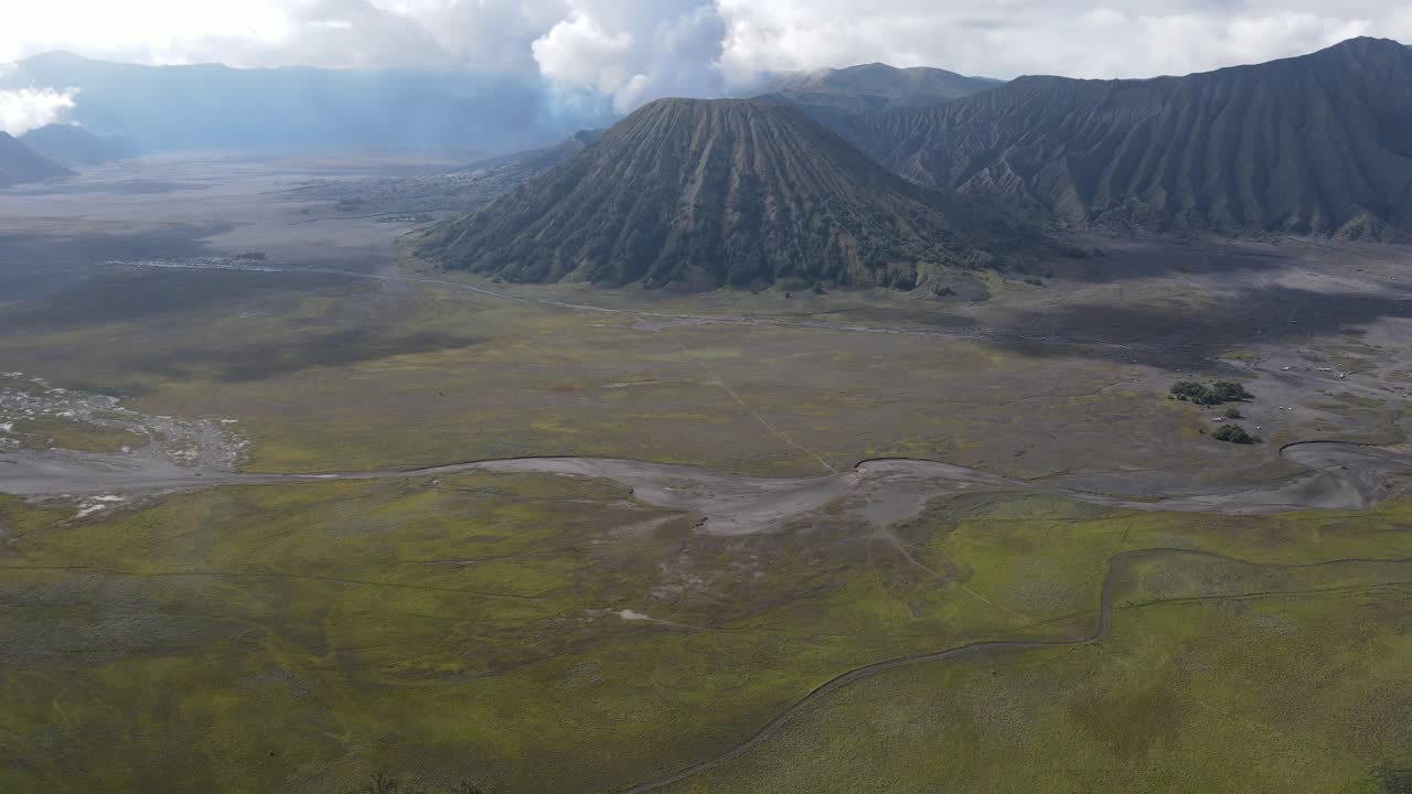 vista aérea, por la mañana, la hermosa zona del monte bromo está ligeramente humeante y la sabana es verde