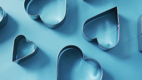 heart shape cookie cutters on blue background at valentine's day