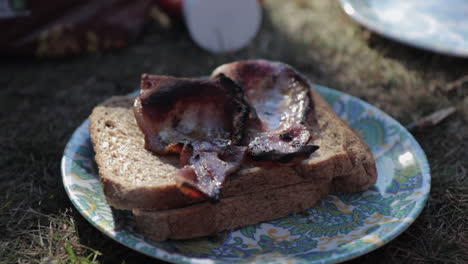 tiro ascendente de sándwich de tocino cocinado durante las vacaciones de camping