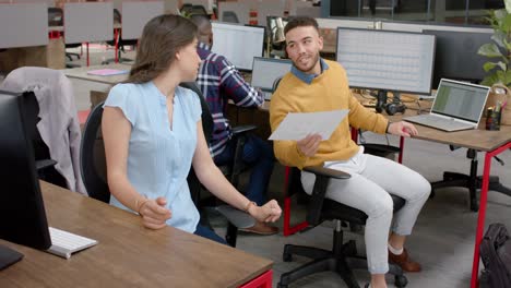 caucasian woman giving a document to biracial man at office