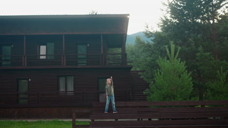 girl launches flying toy near eco hotel building in forest