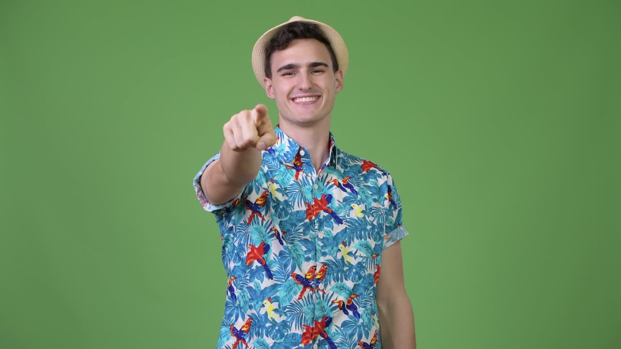 Young handsome tourist man pointing at camera