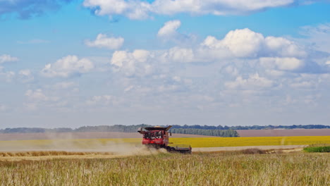 Agricultural machinery working on the field in rural countryside. Harvesting on the farmland during sunny summer day. Crop farming concept.