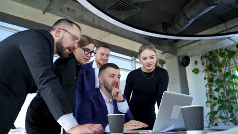 team of entrepreneurs working together. group of business partners work on a laptop and discuss new project in office room.