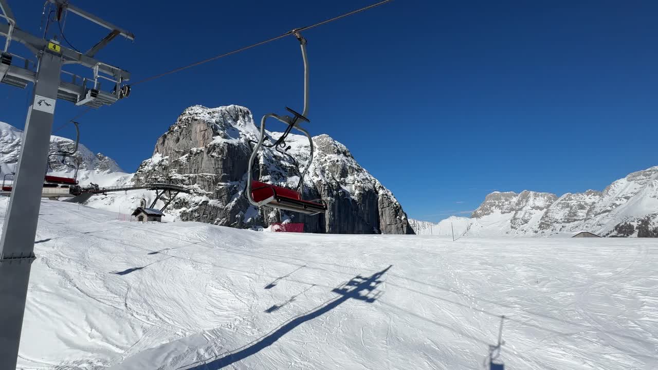 Chairlift on a sunny day in a ski resort. Italian Alps.