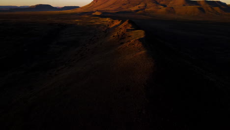 mountain tops highlighted by sunset in semi-arid desert region, drone