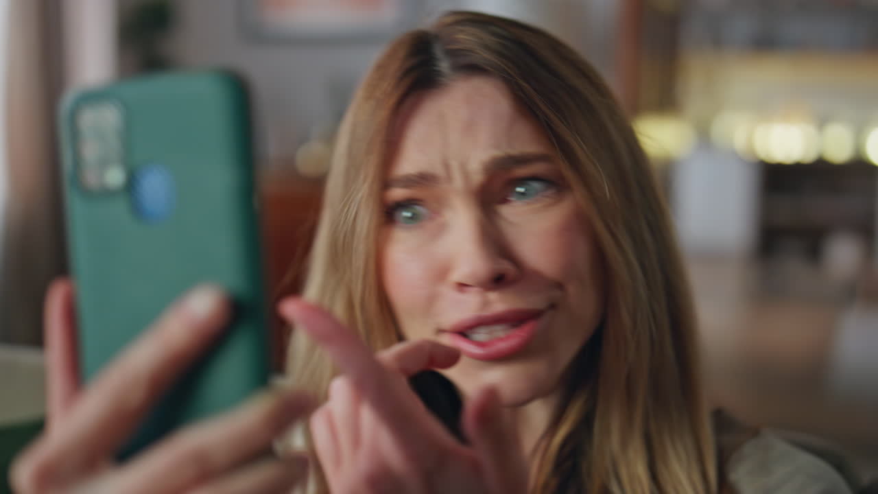 Excited woman video call by smartphone application home. Portrait girl talking