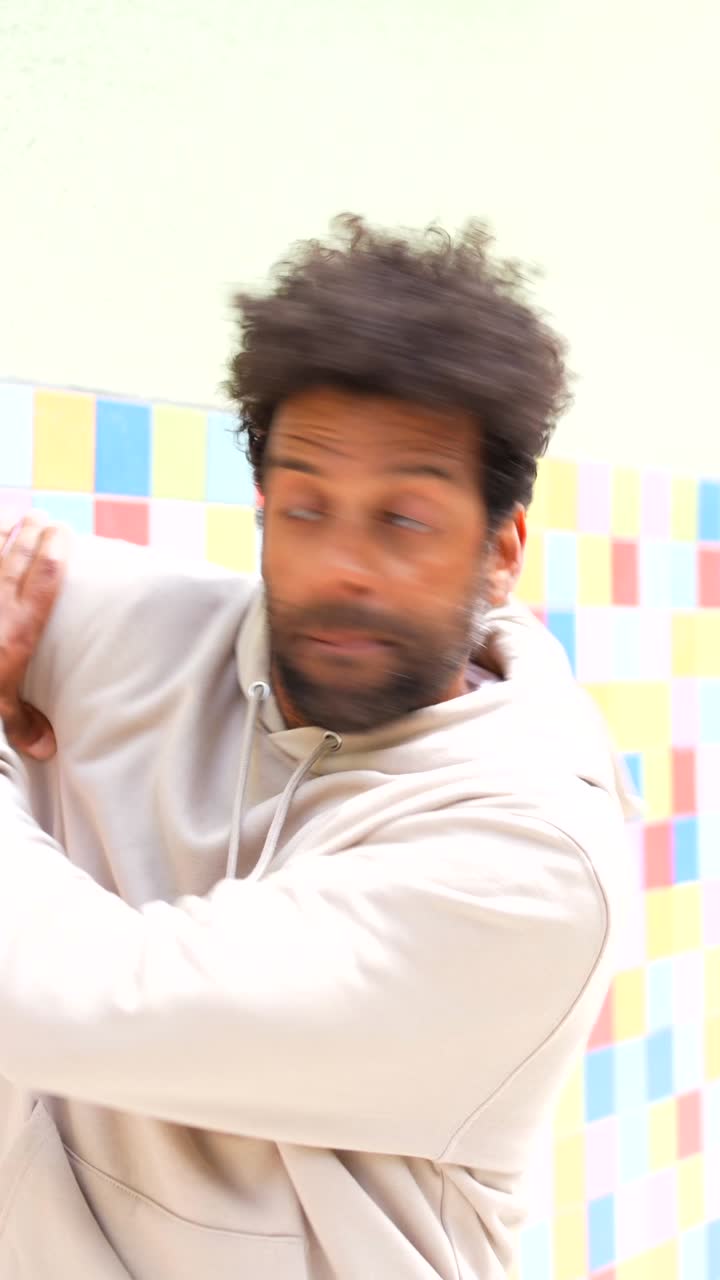 Man dancing in front of a tiled wall
