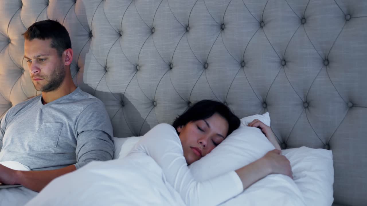 여자 가 침대 에서 자고 있는 동안 노트북 을 사용하는 남자 4k