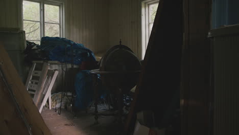 dimly lit room with wood-paneled walls, a vintage globe, and various items piled together.