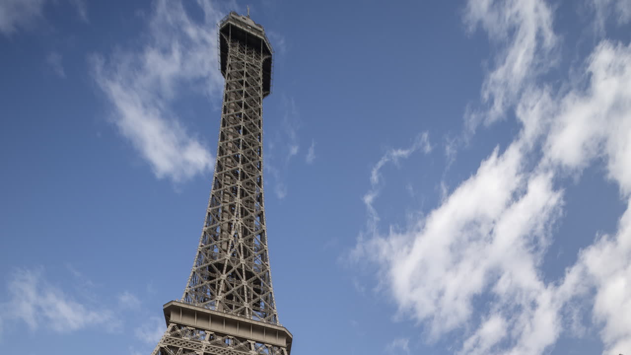 Torre Eiffel sotto un cielo azzurro con nuvole in movimento