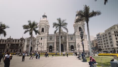 people walking at plaza mayor with lima metropolitan cathedral in peru. - pov shot