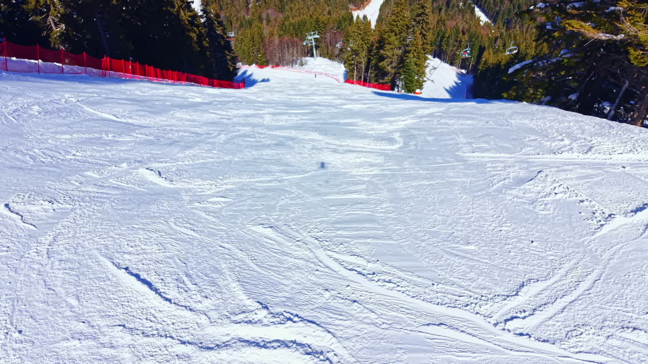 Ombra di drone che vola sopra una pista da sci invernale vuota.