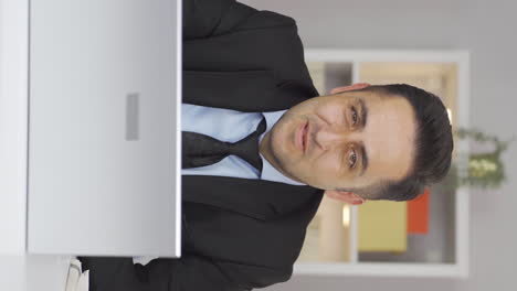 Vertical-video-of-Home-office-worker-man-looking-smugly-at-camera.