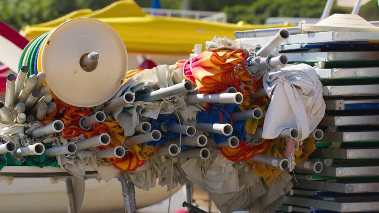 Beach umbrellas stacked at Guidaloca Beach, Sicily, Italy in the summer sun