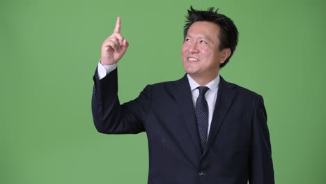 녹색 배경에 성숙한 일본 사업가