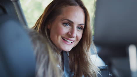 mother turning round to talk to children in back seat on car journey
