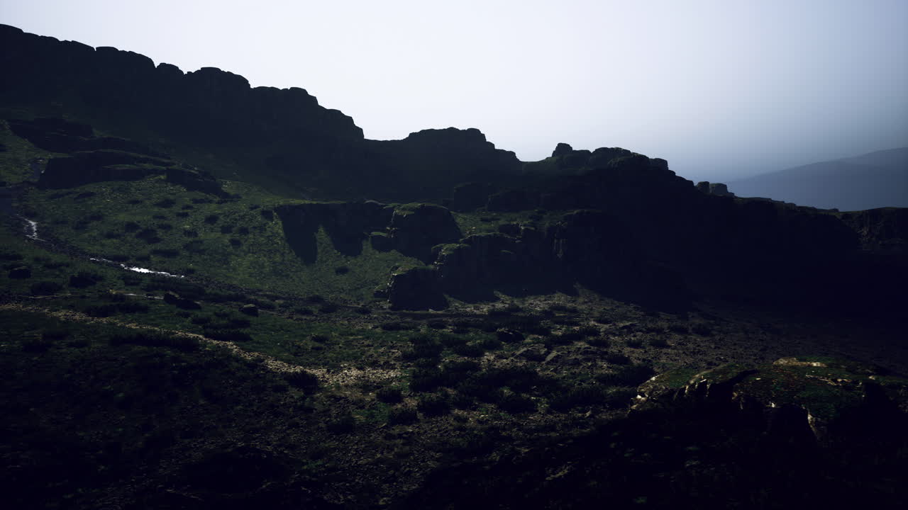 Majestic mountain landscape with rugged terrain under a hazy sky during midday