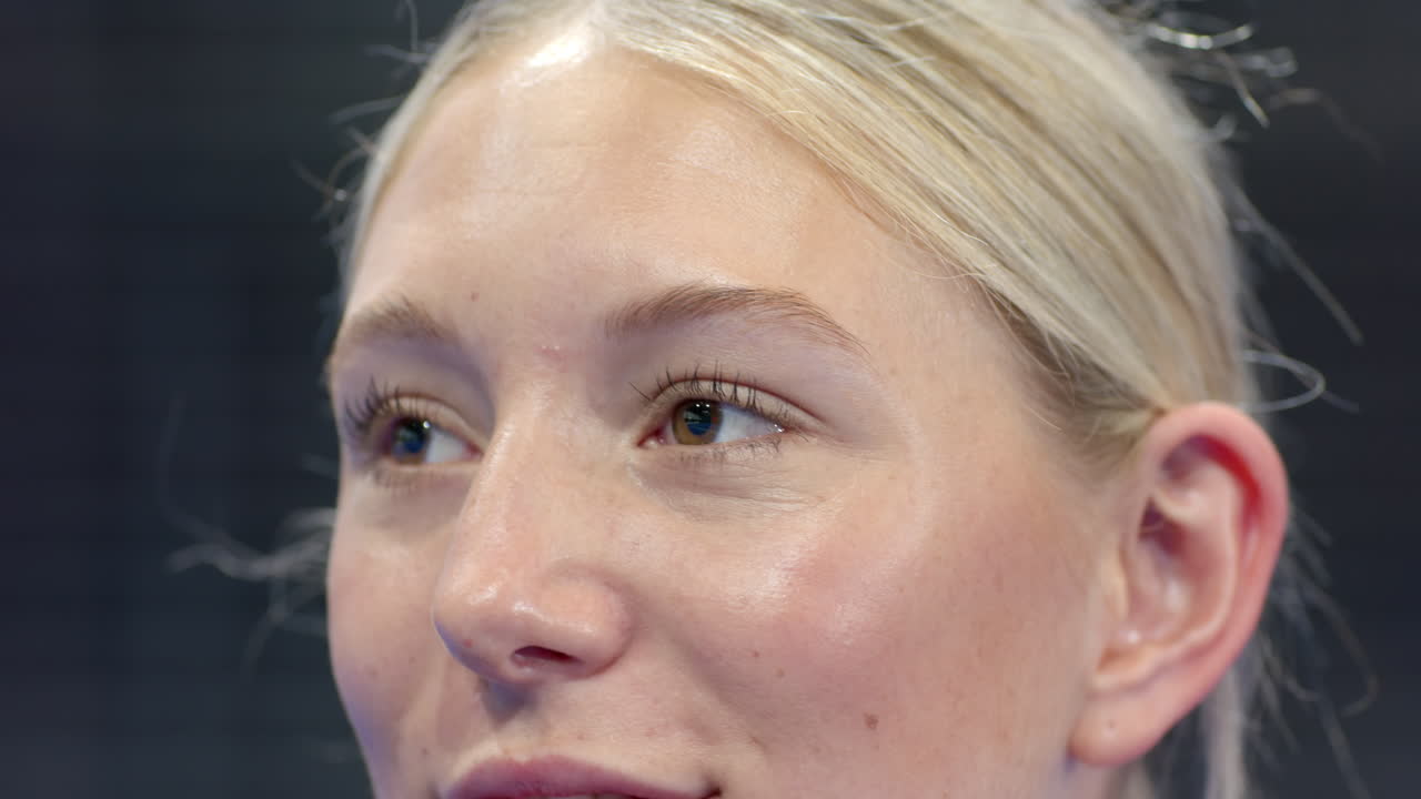 Smiling woman enjoying padel tennis match, showing excitement and happiness, at indoor court