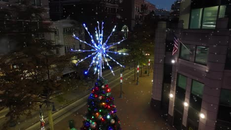 tight aerial of lit star on christmas tree in downtown usa city