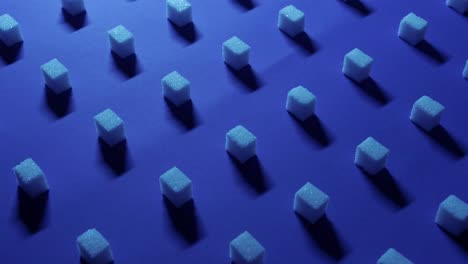 vista panorámica rápida de derecha a izquierda de un fondo cúbico único con cubos de azúcar blanco dispuestos en filas sobre un fondo azul oscuro, efecto 3d