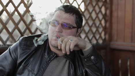 Businessman-relaxing-and-smoking-cigarette-on-terrase