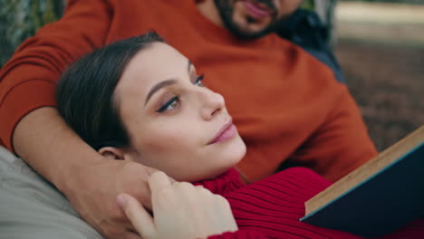 mujer tierna relajándose picnic acostado en el hombre verticalmente cerca. pareja romántica