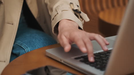 estudiante caucásica haciendo compras en línea en una computadora portátil al aire libre.