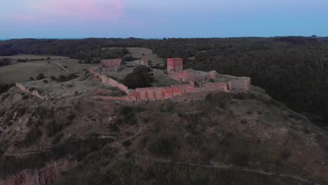 Aerial-slow-push-in-on-Ruin-of-Hammershus-on-Bornholm,-Denmark-during-sunset-in-summer