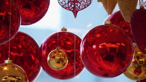 christmas and new year decoration. christmas big red balls on  background of luminous lanterns and gold garlands. holiday background. blinking garland. red baubles with lights twinkling close up.