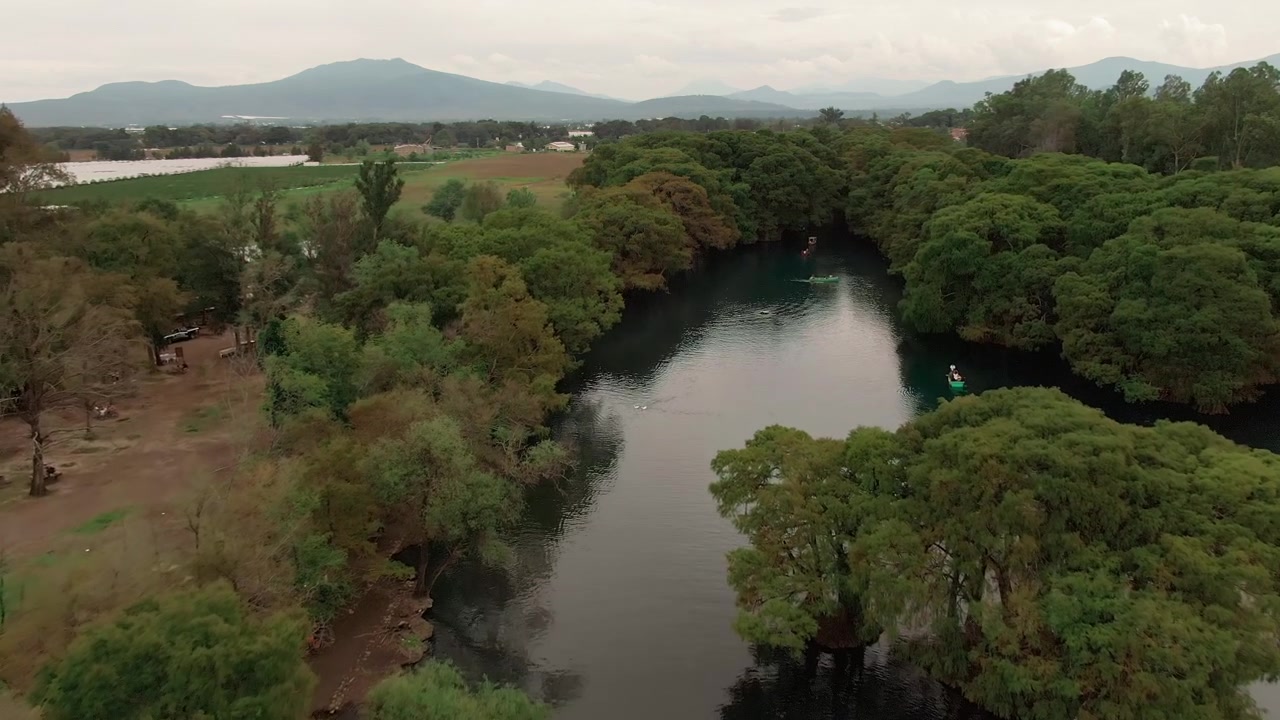 Turistas en barcas en el Lago Camécuaro en Michoacán, México - Toma aérea con dron