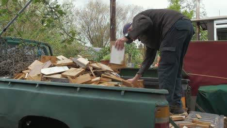 mature man unloading a truckload of scrap timber